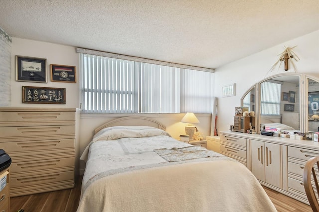 bedroom with a textured ceiling and light wood-type flooring