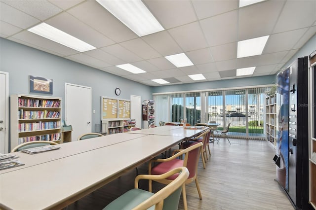 kitchen with light hardwood / wood-style flooring, a paneled ceiling, and a breakfast bar