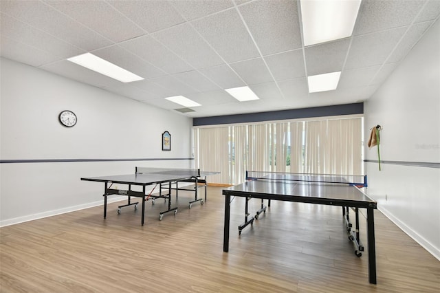 playroom with a paneled ceiling and light hardwood / wood-style flooring