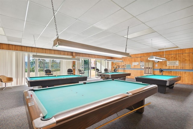 playroom with a drop ceiling, dark carpet, wooden walls, and pool table