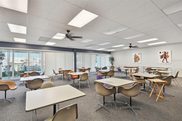 interior space featuring dark carpet, a paneled ceiling, and ceiling fan