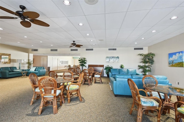 carpeted dining room featuring a drop ceiling and ceiling fan