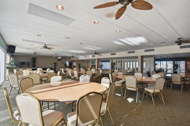 carpeted dining area featuring a paneled ceiling and ceiling fan