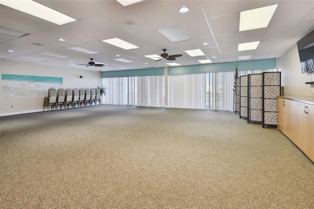 interior space with ceiling fan and a drop ceiling