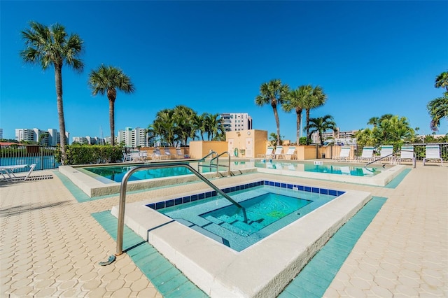 view of pool with a hot tub and a patio area