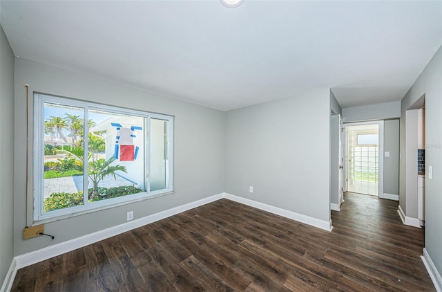 empty room with dark hardwood / wood-style flooring