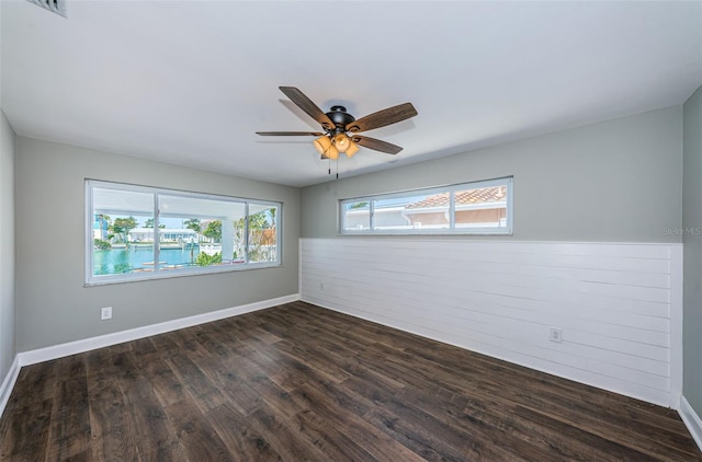 empty room with ceiling fan and dark hardwood / wood-style floors