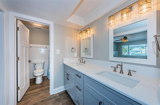 bathroom with vanity, ceiling fan, crown molding, wood-type flooring, and toilet