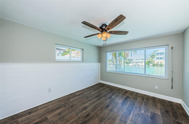 spare room with dark hardwood / wood-style floors and ceiling fan