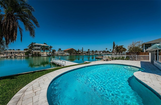 view of swimming pool with a water view, a patio, and a dock