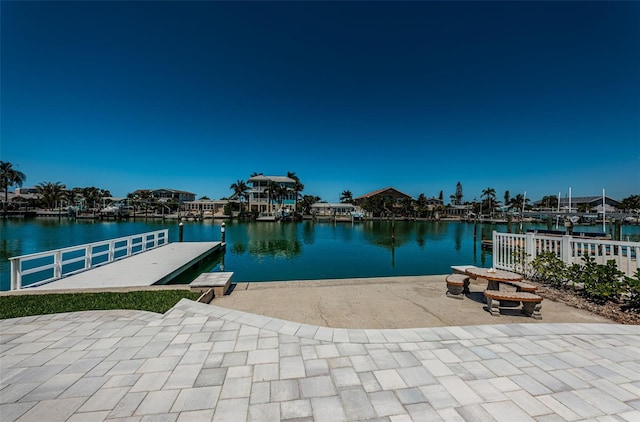 dock area with a patio and a water view