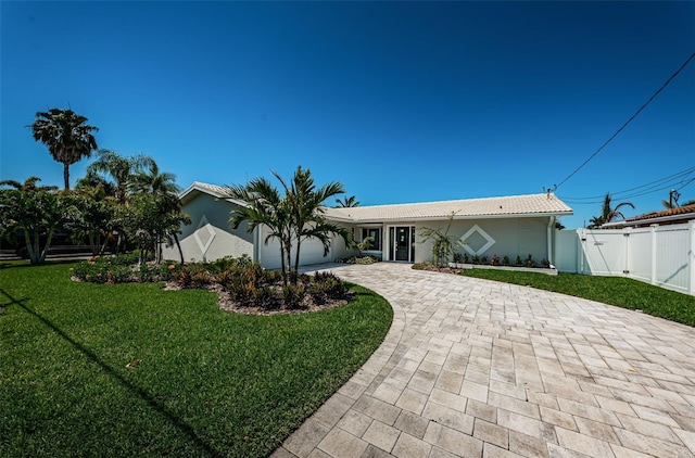 single story home featuring a front lawn and a garage