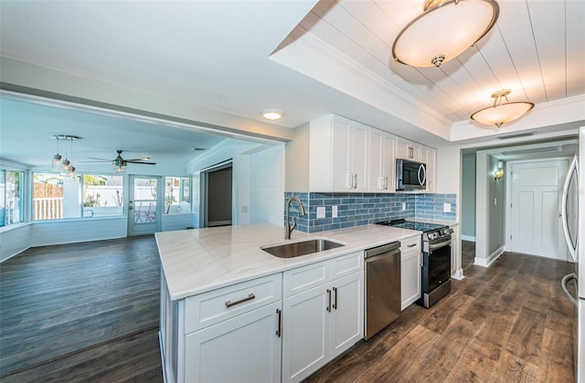 kitchen with backsplash, sink, white cabinetry, and stainless steel appliances