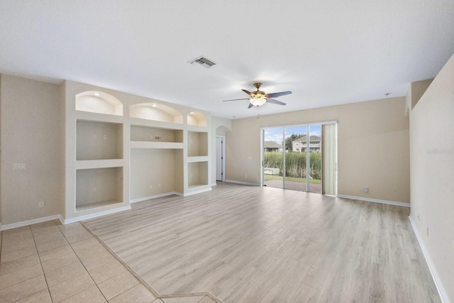 unfurnished room with light wood-type flooring, built in features, and ceiling fan