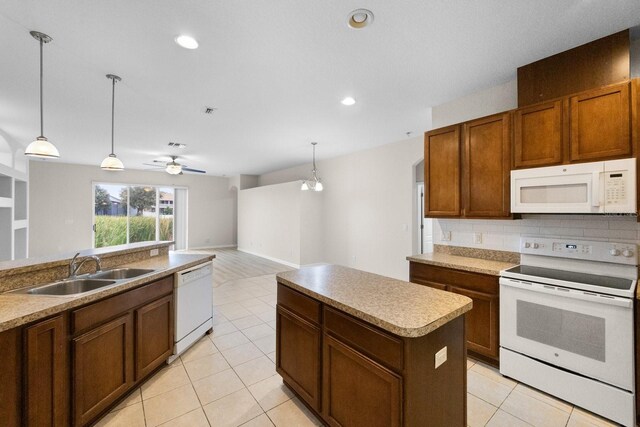 kitchen with white appliances, sink, decorative light fixtures, a kitchen island, and ceiling fan