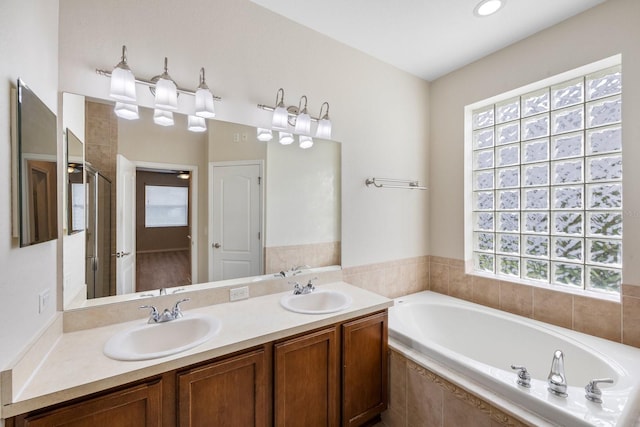 bathroom with vanity and shower with separate bathtub