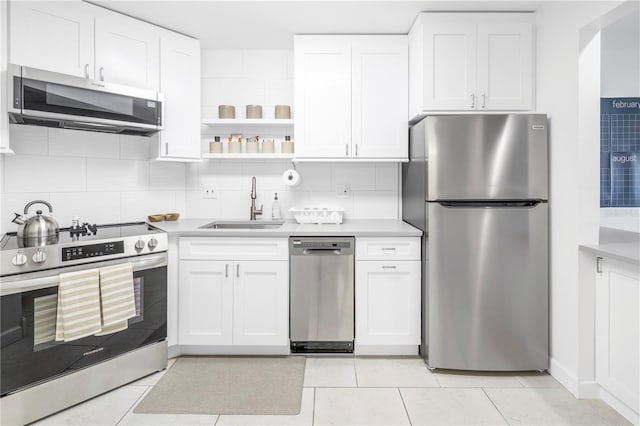 kitchen with tasteful backsplash, stainless steel appliances, light tile floors, and sink