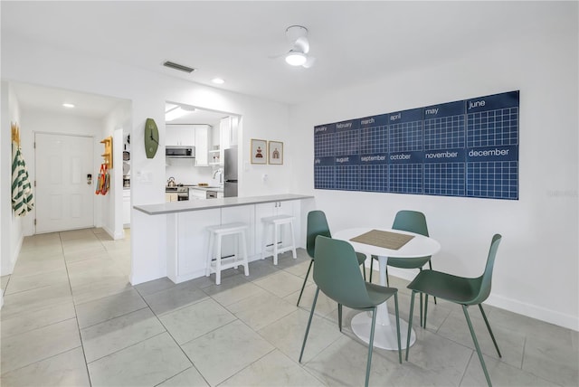 dining room featuring ceiling fan and light tile flooring