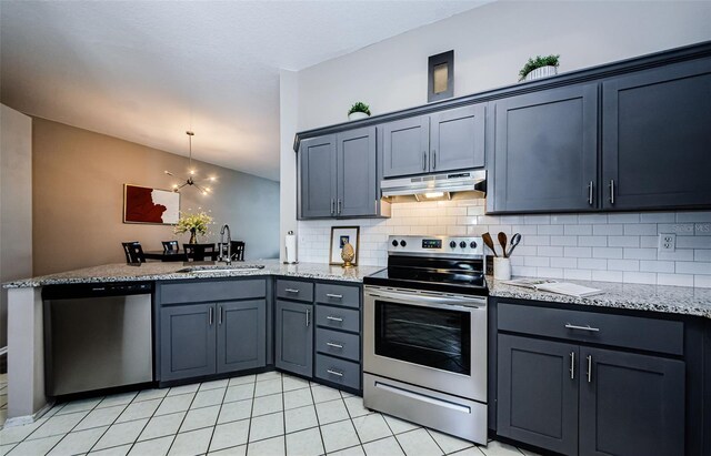 kitchen with backsplash, sink, hanging light fixtures, light stone counters, and stainless steel appliances