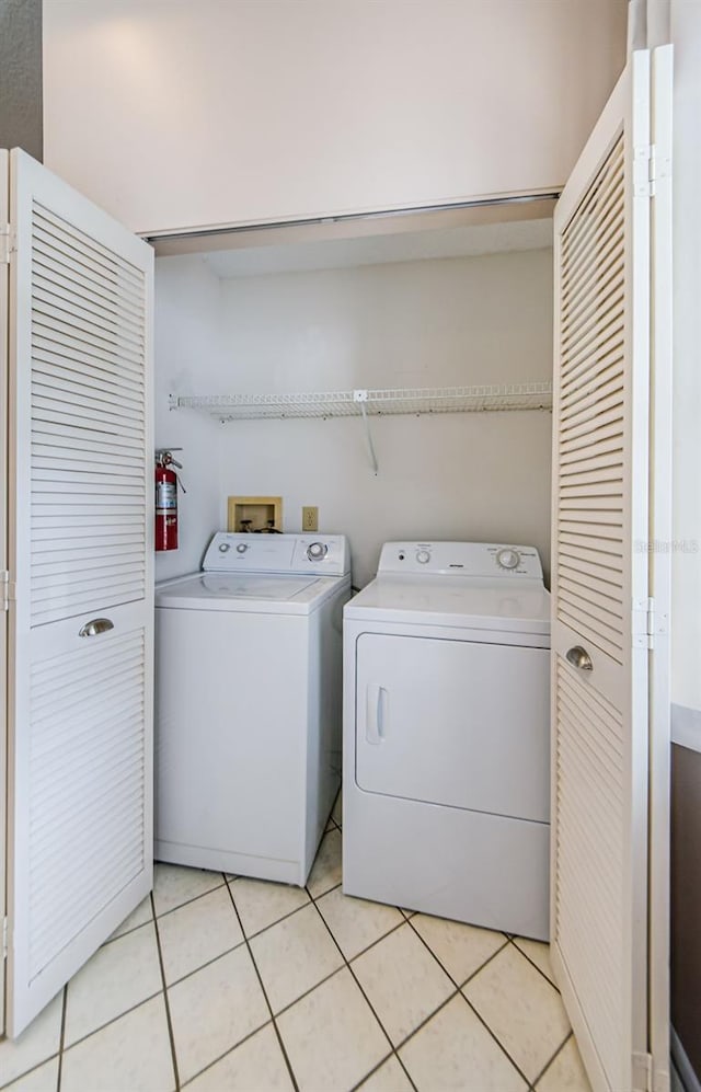 washroom featuring light tile patterned floors and washer and clothes dryer