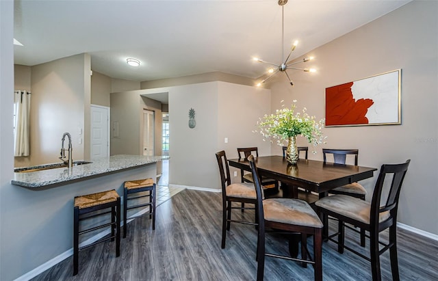 dining room featuring dark hardwood / wood-style flooring, sink, and a chandelier