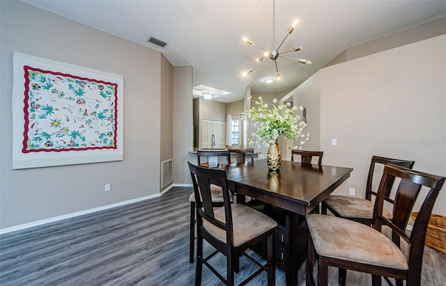 dining area featuring dark hardwood / wood-style floors, a skylight, and a notable chandelier