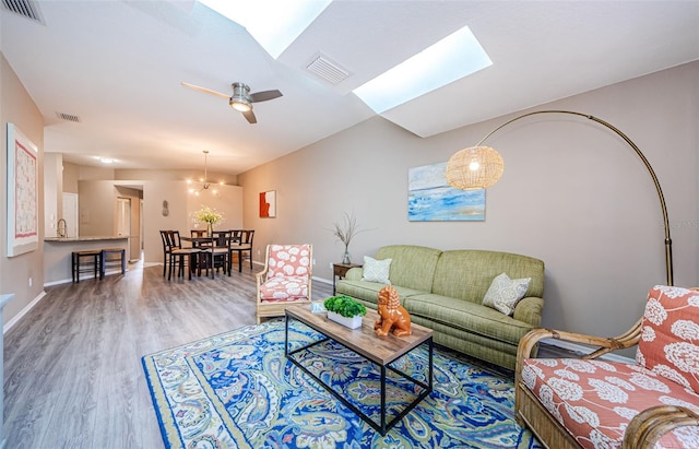 living room featuring hardwood / wood-style floors, ceiling fan, and sink