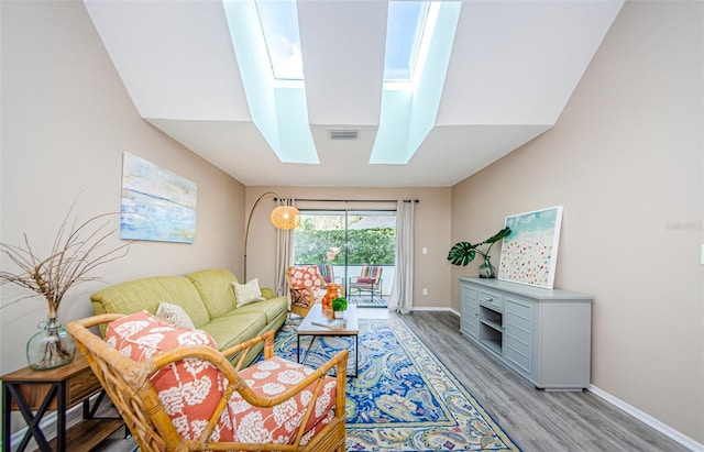 living room with light hardwood / wood-style floors and a skylight