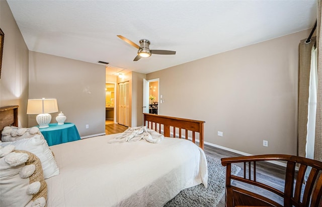 bedroom featuring ceiling fan, a closet, wood-type flooring, and ensuite bath