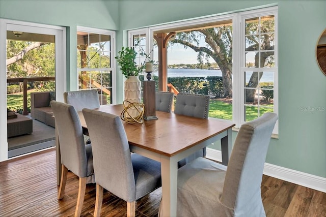 dining area featuring a water view and hardwood / wood-style flooring