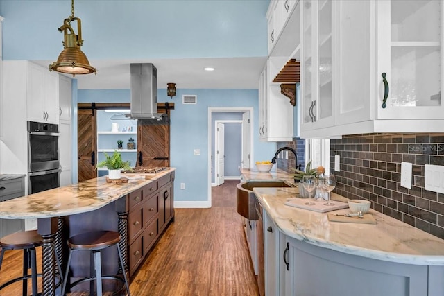 kitchen featuring a center island, white cabinets, pendant lighting, and a barn door