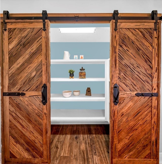 details with hardwood / wood-style flooring and a barn door