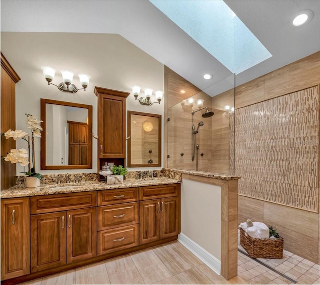 bathroom with tile patterned flooring, vanity, tile walls, a tile shower, and lofted ceiling with skylight