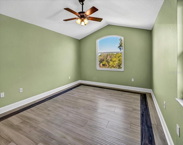 spare room featuring light hardwood / wood-style floors, a textured ceiling, ceiling fan, and vaulted ceiling