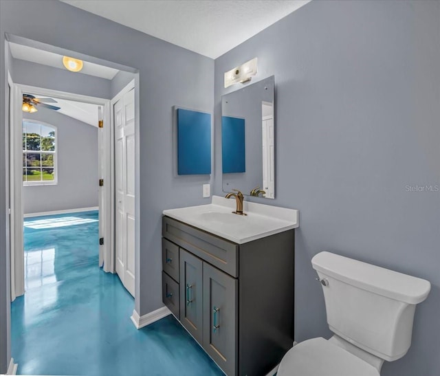 bathroom featuring toilet, vanity, concrete flooring, and ceiling fan