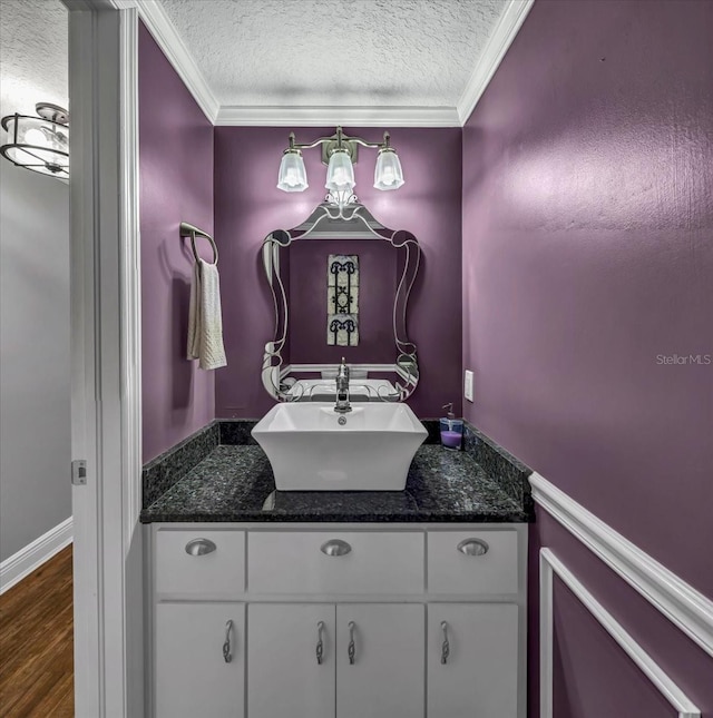 bathroom featuring vanity, crown molding, hardwood / wood-style flooring, and a textured ceiling