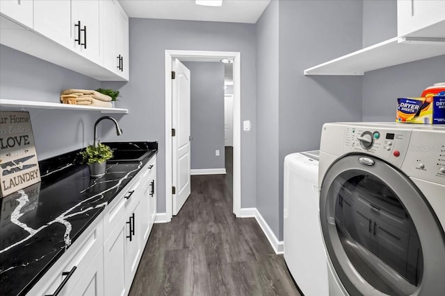 laundry area with cabinets, washer and dryer, sink, and dark wood-type flooring