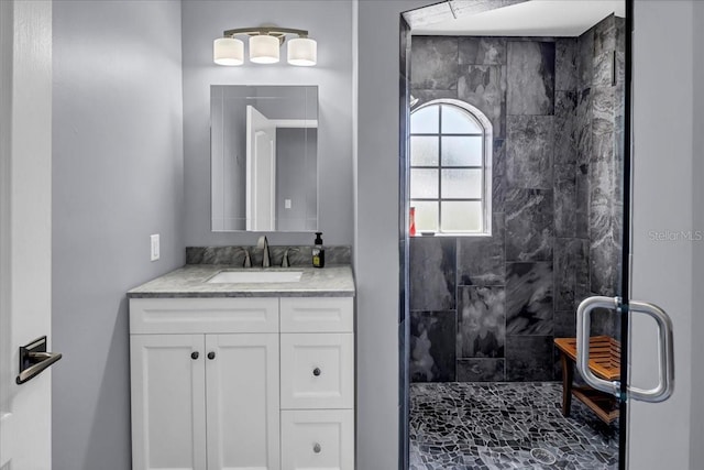 bathroom with vanity and a tile shower