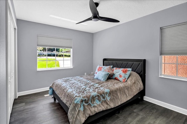 bedroom with dark wood-type flooring, ceiling fan, a closet, and a textured ceiling