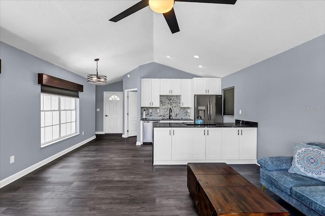 kitchen featuring hanging light fixtures, white cabinetry, stainless steel appliances, lofted ceiling, and dark hardwood / wood-style floors