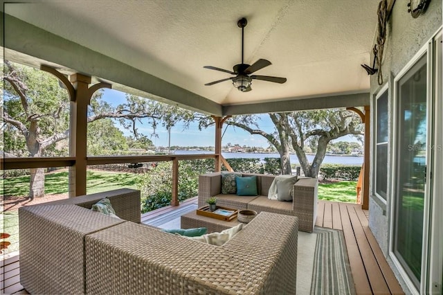 deck with ceiling fan, a water view, and an outdoor hangout area