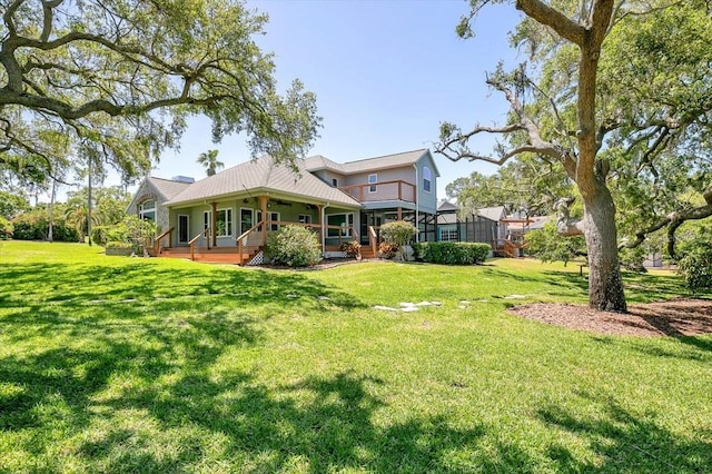 rear view of property with a yard and covered porch