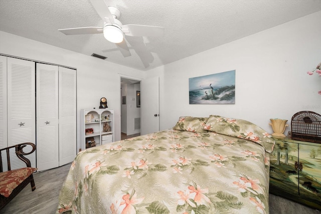 bedroom featuring a closet, ceiling fan, dark hardwood / wood-style floors, and a textured ceiling