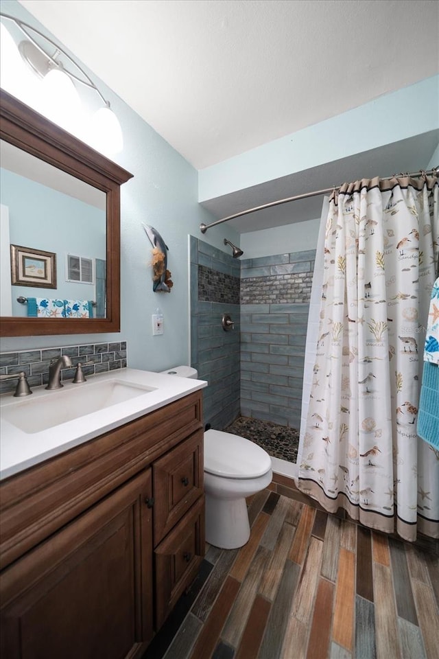 bathroom with walk in shower, toilet, tasteful backsplash, vanity, and hardwood / wood-style flooring