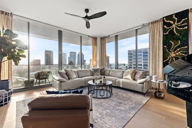 living room featuring floor to ceiling windows, light hardwood / wood-style flooring, and ceiling fan