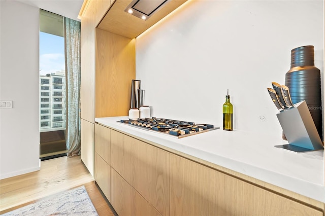 kitchen with light brown cabinets, stainless steel gas cooktop, and light wood-type flooring