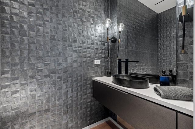 bathroom featuring vanity and tile walls