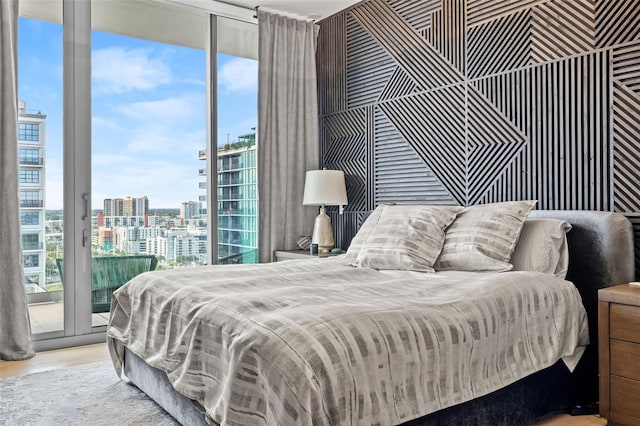 bedroom featuring light hardwood / wood-style floors and a wall of windows