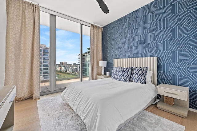 bedroom featuring floor to ceiling windows, ceiling fan, access to exterior, and light wood-type flooring