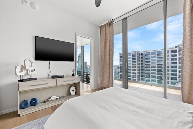 bedroom with light hardwood / wood-style flooring, ceiling fan, and multiple windows